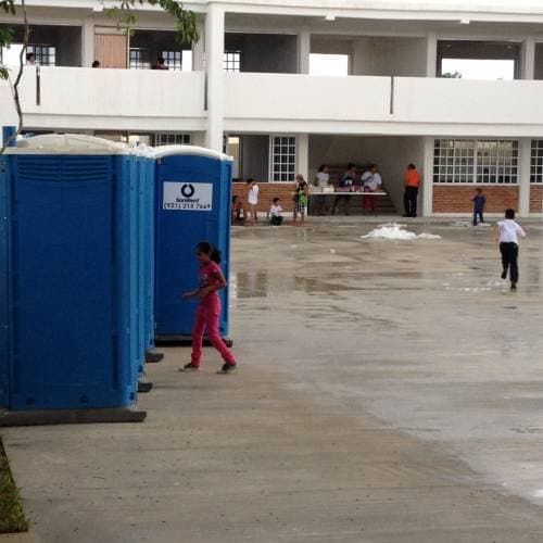 Estudiantes toman clases; a un lado los albañiles trabajan